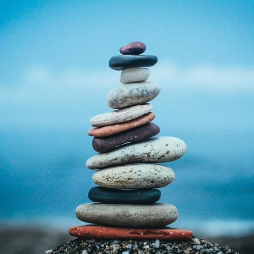 A stack of perfectly balanced stones on a calm beach, representing inner peace.